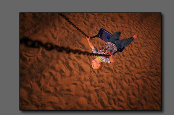 Boy enjoys swinging.